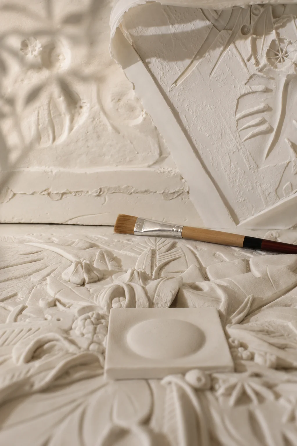 Handcrafted bas-relief process with sculpted plaster details and artist brush by AnaKleo Studio